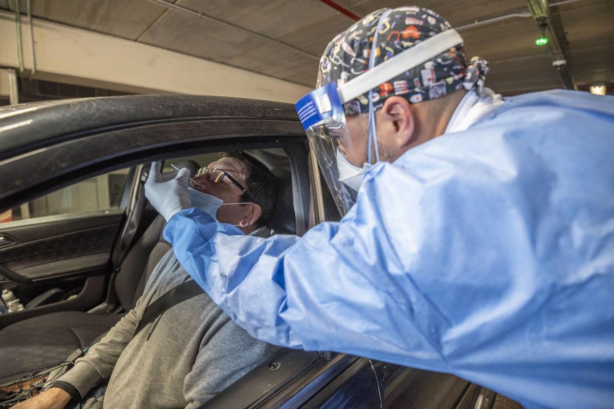 Un sanitario realiza una prueba PCR en el coroauto de Cazoña