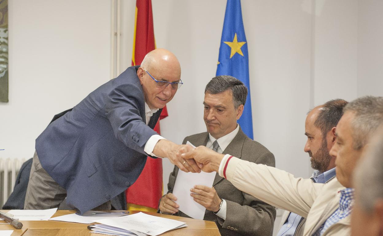 El alcalde de Miengo dando la mano a un concejal en presencia del secretario y el portavoz del PP en su investidura. 