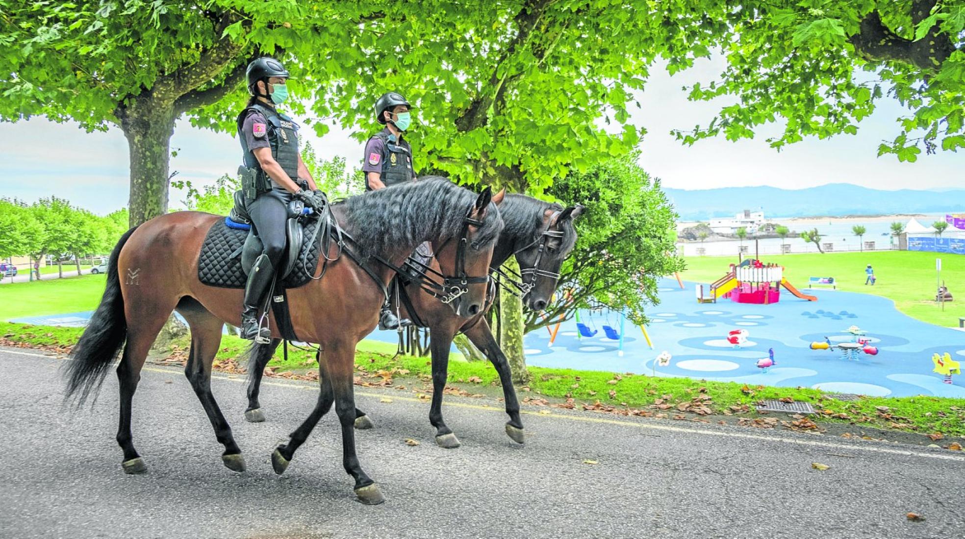 Dos agentes de policía montados a caballo patrullan por la Península de la Magdalena. daniel pedriza