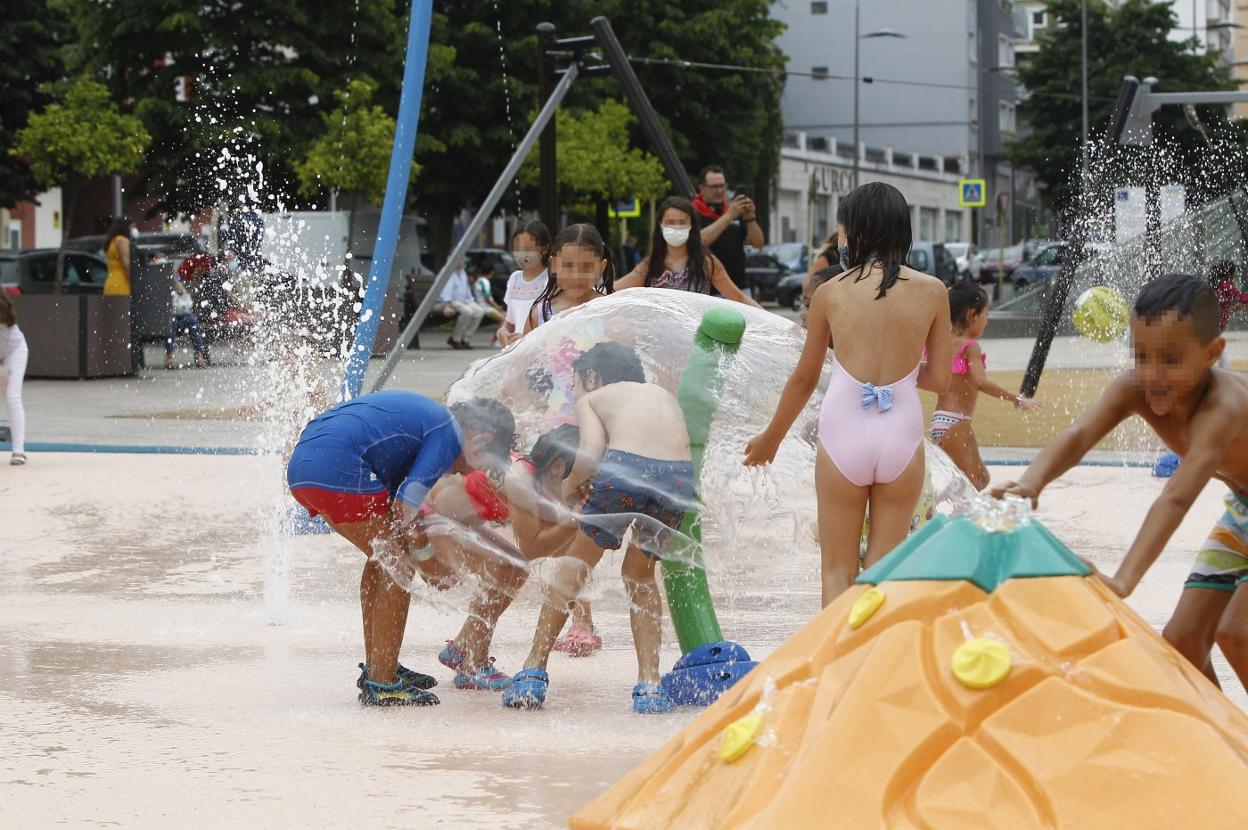 Los primeros niños en disfrutar, este viernes, del parque del agua de la plaza de La Llama. 