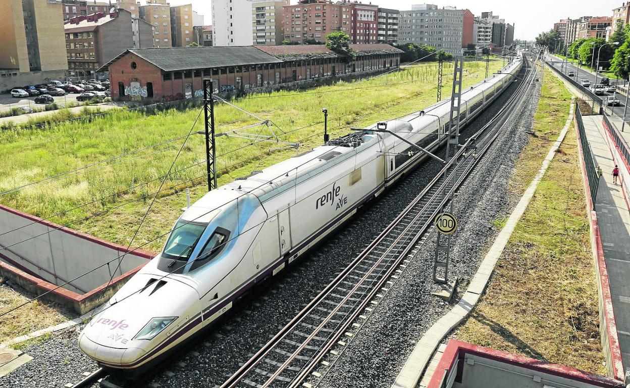 Vías de tren y estación pequeña de Palencia con un tren de alta velocidad. antonio quintero