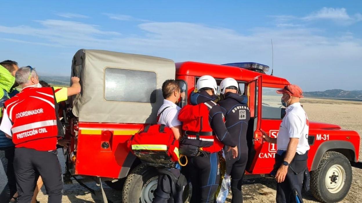 Momento en el que los buzos introducen a la mujer en el vehículo de emergencias. 