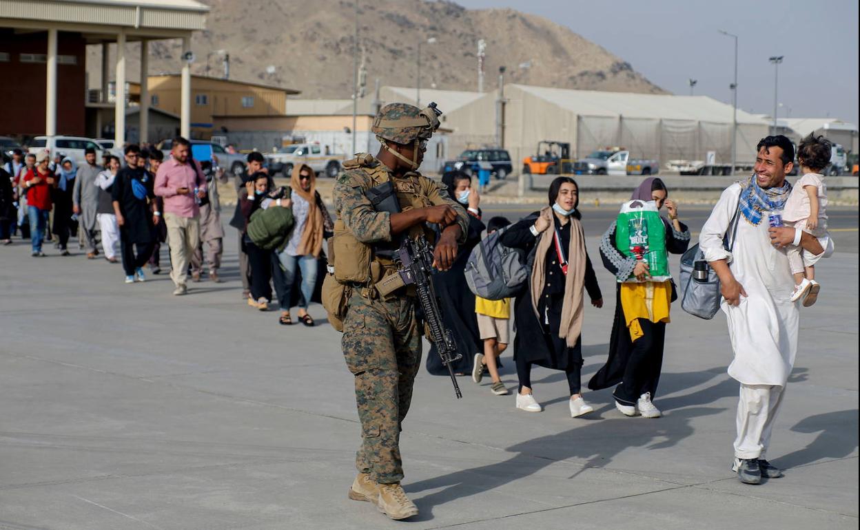 Un infante de la Marina estadounidense escolta a los evacuados en el Aeropuerto Internacional Hamid Karzai de la capital afgana. 