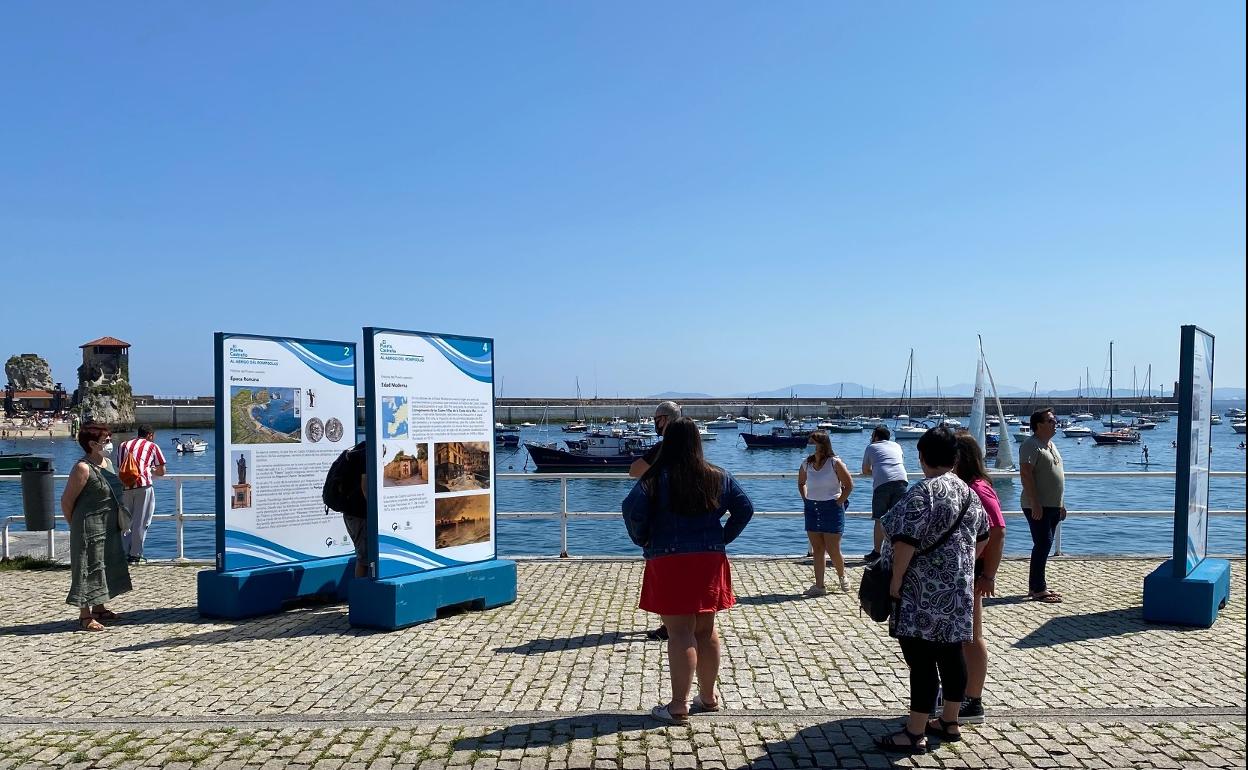 Visitantes en la exposición al aire libre 'Al abrigo del rompeolas, el puerto castreño'.