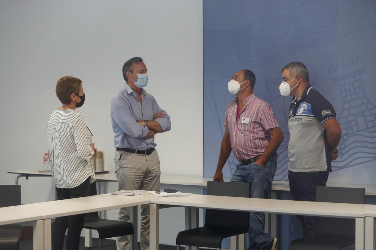 Guillermo Blanco, segundo por la izquierda, charla con los representantes de los ganaderos. 
