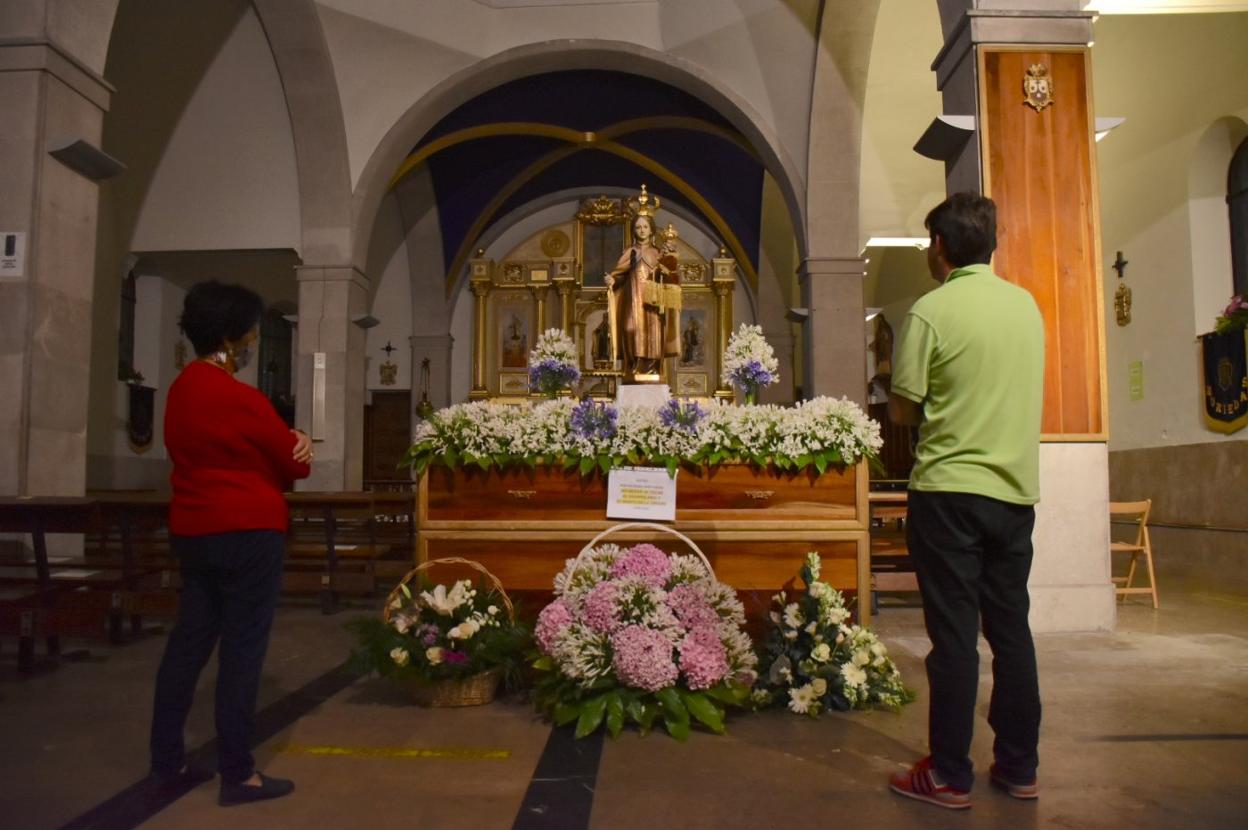 La pedánea de Revilla, Raquel Cuerno, y el párroco de la iglesia, Óscar Lavín, ante la imagen de la Virgen. 