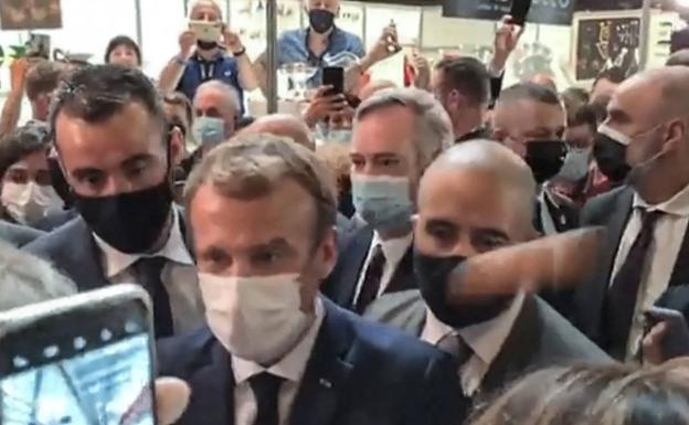 Un huevo vuela arrojado contra, Emmanuel Macron, este lunes durante su visita a una feria gastronómica en Lyon.