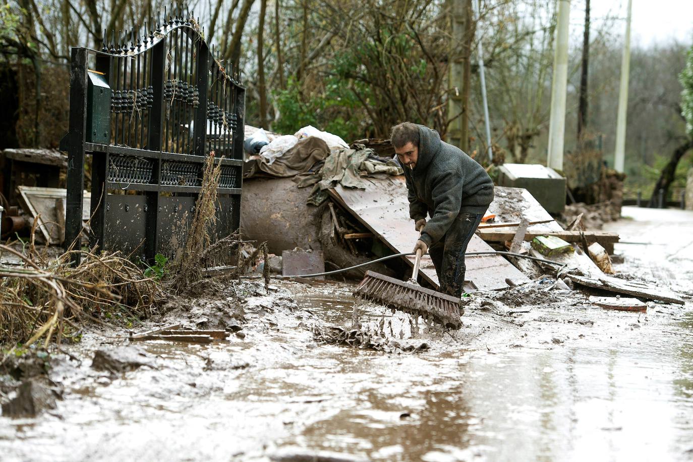 Imagen de archivo de un vecino tras la crecida del Saja, a su paso por Caranceja, que provocó las inundaciones de enero de 2019.