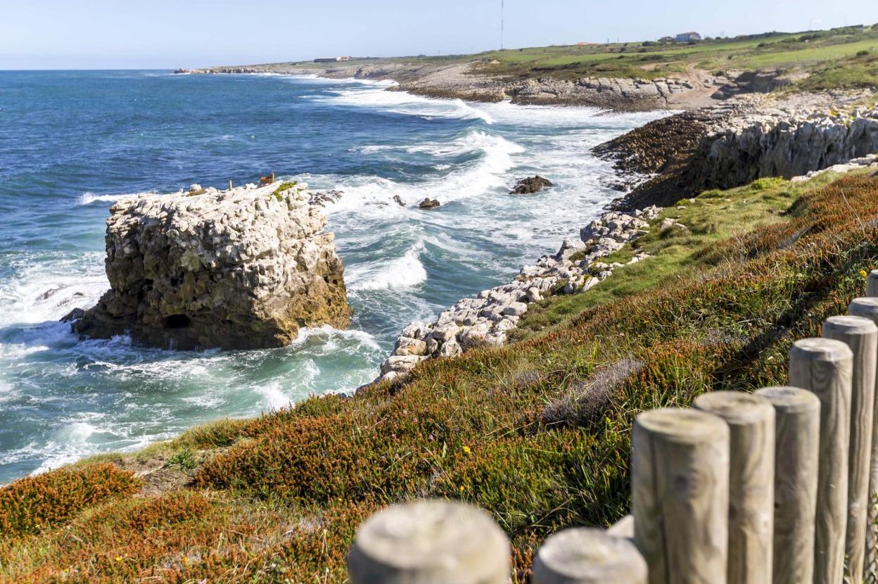 La roca, en mitad del mar y con una altura considerable, se ve desde la senda costera. Hay que fijarse en la parte alta.