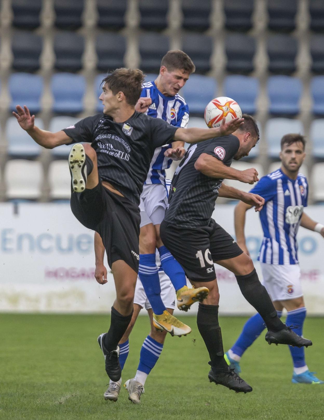 Somavilla pugna por un balón con dos jugadores del Textil. 