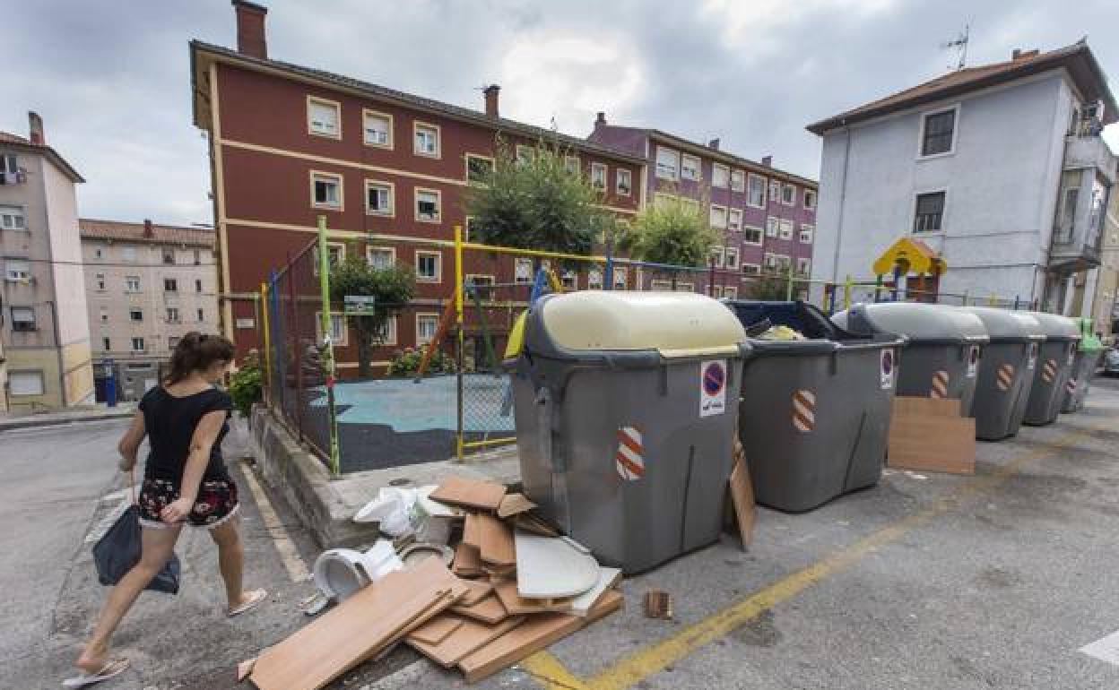 Contenedores rotos con basura acumulada alrededor, en el entorno de la calle Alta