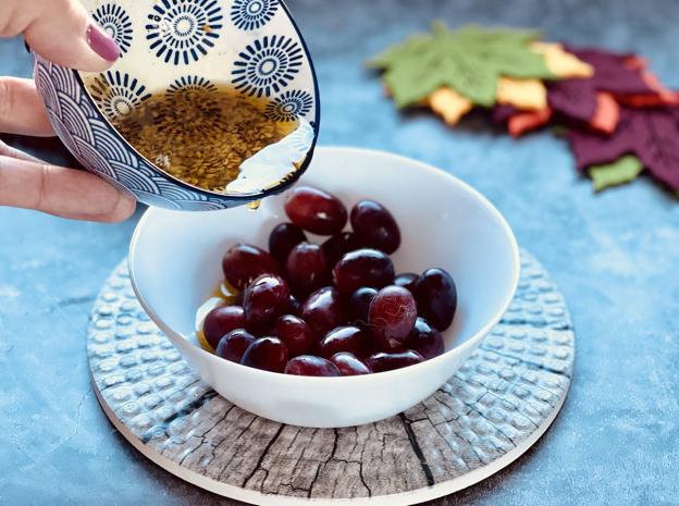 Macerar las uvas en vinagre, aceite, ajo, azúcar, sal y semillas de hiojo o de lino.