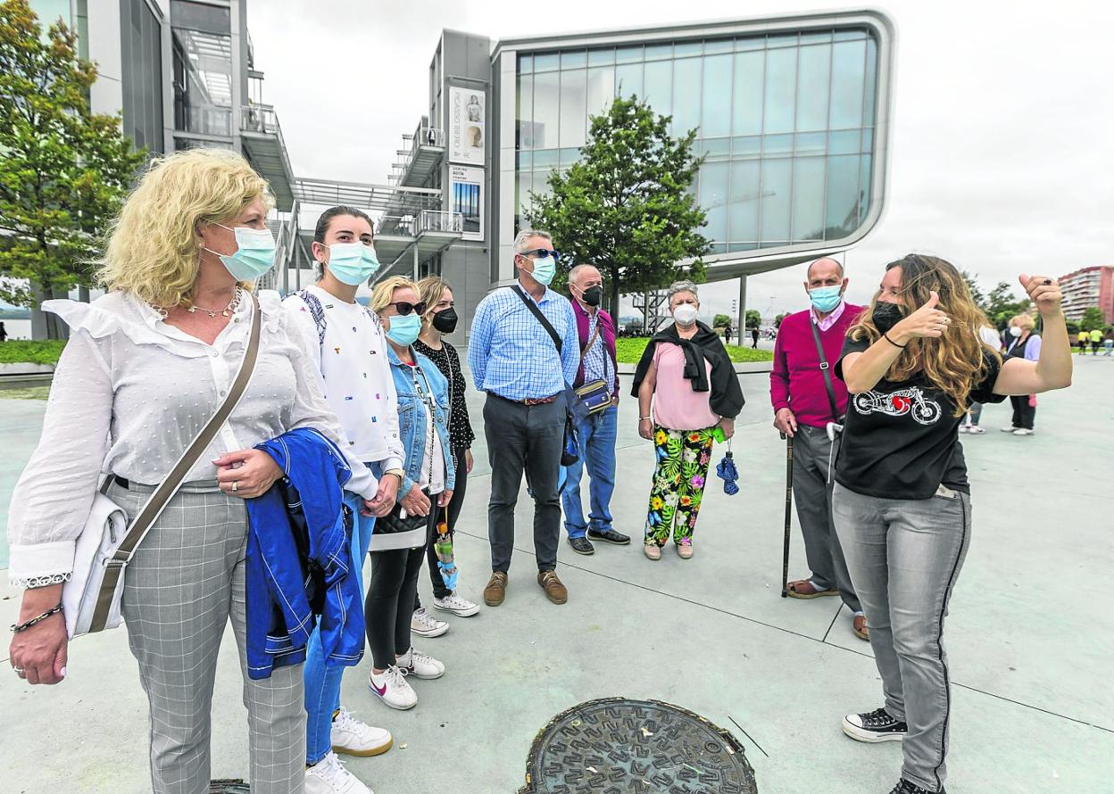 Una guía turística explica el entorno del Centro Botín a unos visitantes en el centro de Santander. 