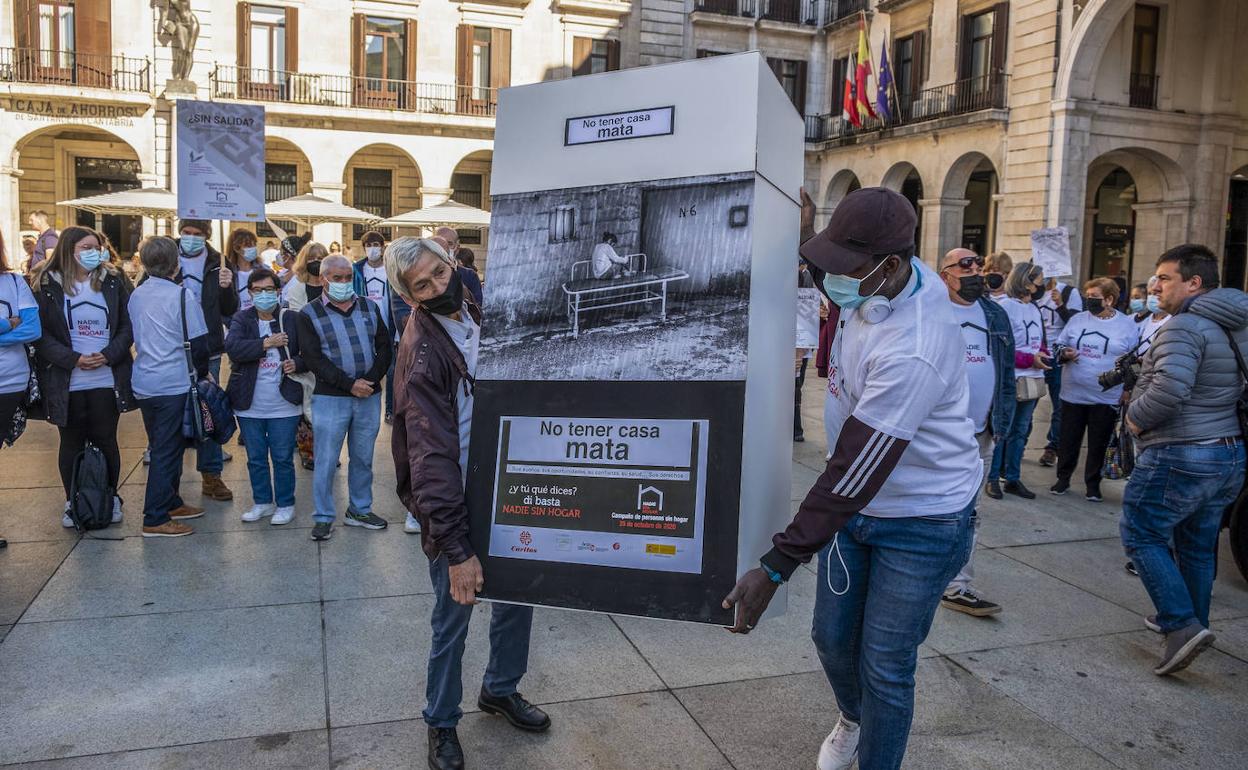 Dos manifestantes, portando una de las pancartas de la concentración en favor de los derechos de las personas sin hogar, en la Porticada. 