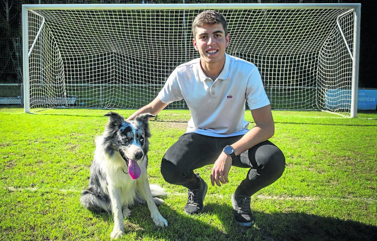 El futbolista Íñigo Sainz-Maza posa con Rocky en la frontal del área pequeña del campo de fútbol de Ampuero. 