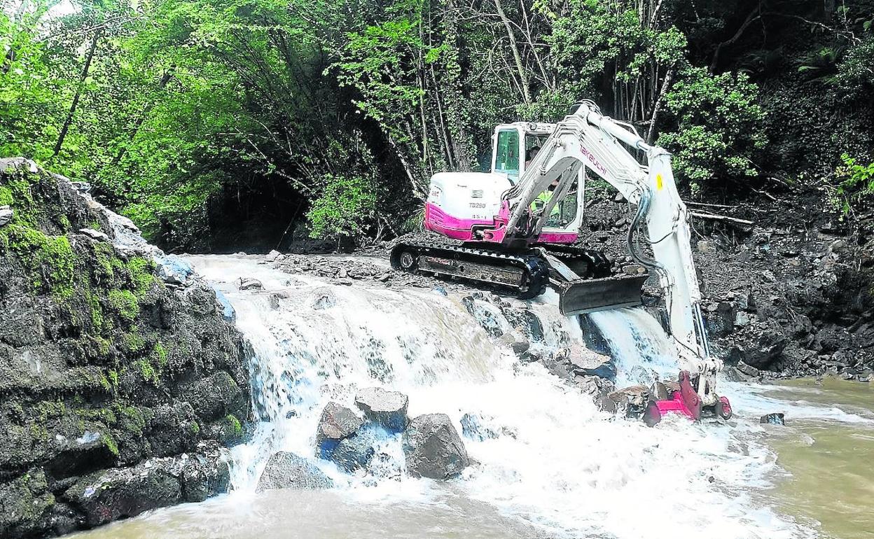 Maquinaria demoliendo el azud situado en el río Bullón, en Ojedo. 