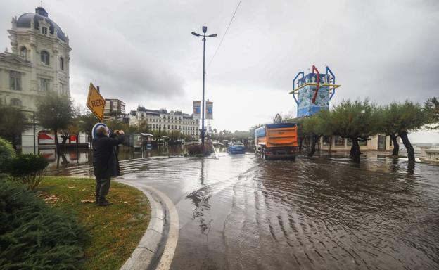 Un vecino saca una foto de las inundaciones ocasionadas, ayer, junto a la Plaza de Italia, debido a las trombas de agua y la falta de mantenimiento del alcantarillado. 