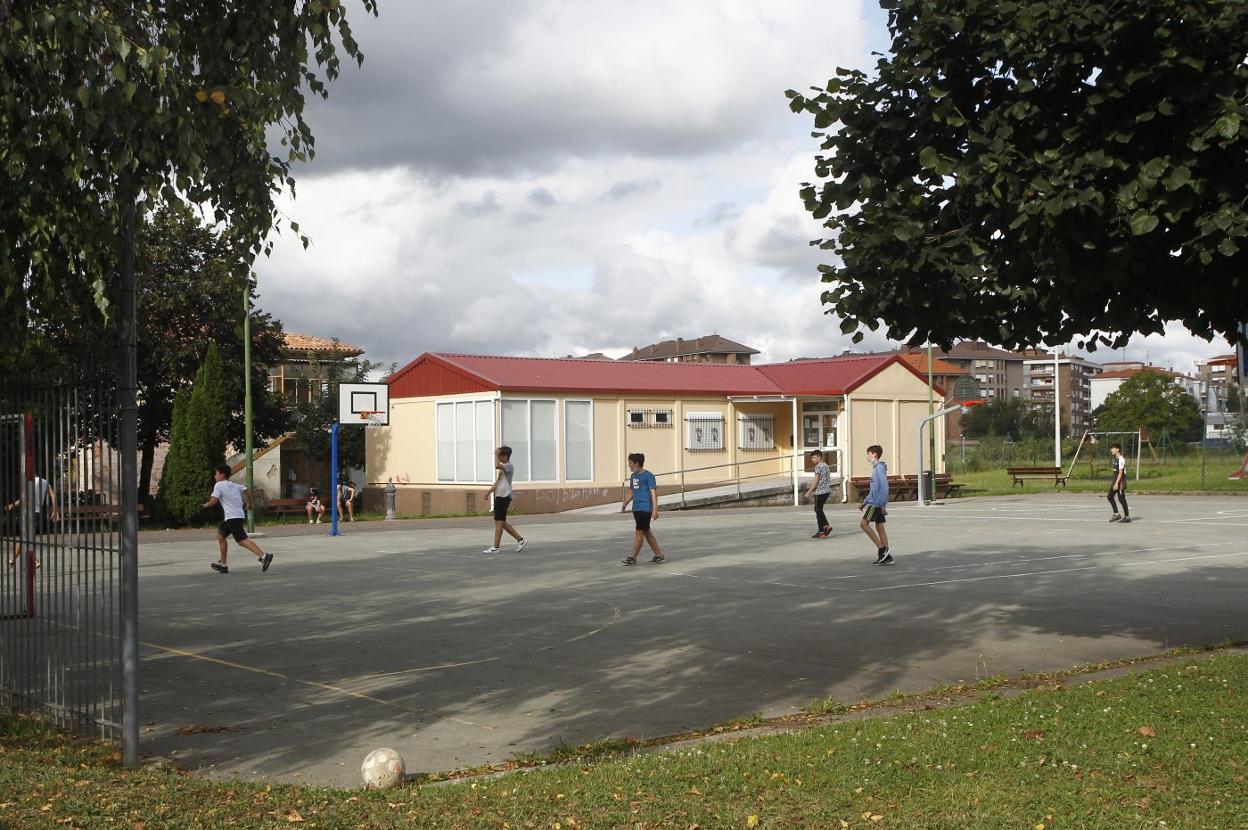 Un grupo de jóvenes juega al fútbol en la pista deportiva de Campuzano. 