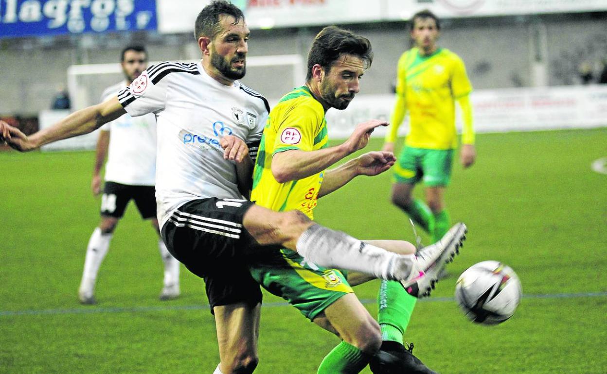 Fresno, del Tropezón, evita que Gabri, del Burgos Promesas, controle el balón. 