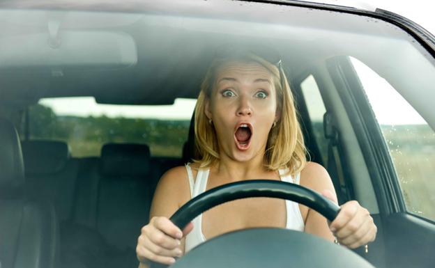 Mujer asustadada al volante.