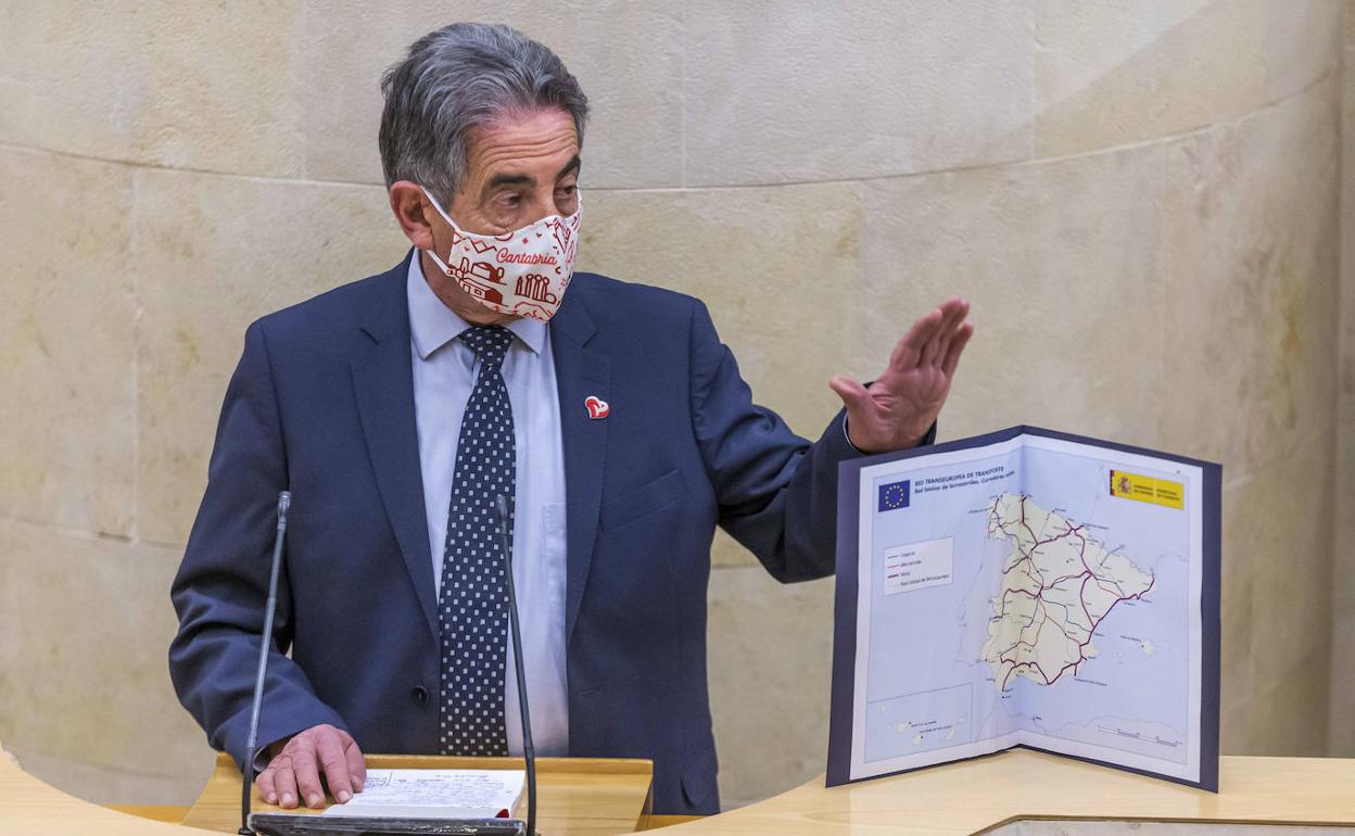 Revilla, en la tribuna del Parlamaneto de Cantabria esta mañana junto al mapa actual del Corredor Atlántico. 