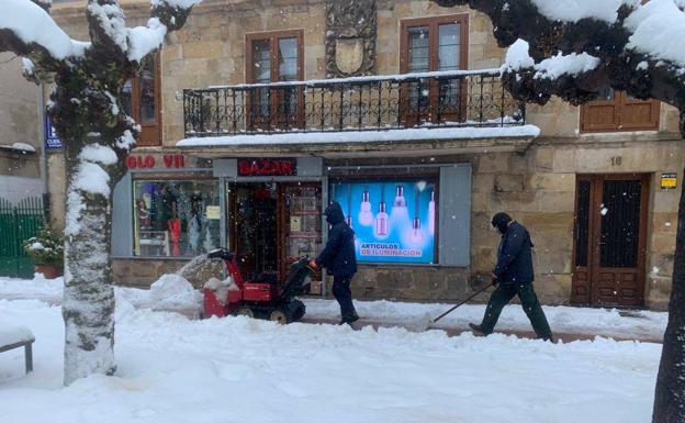 Imagen principal - Máquina quitanieves en las aceras de Reinosa. Vista del teatro de la población y vecinos quitando nieve en Villaescusa.