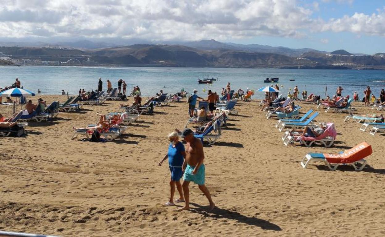 Turistas disfrutan del sol y el mar en la playa de Las Canteras, en Las Palmas de Gran Canaria. 