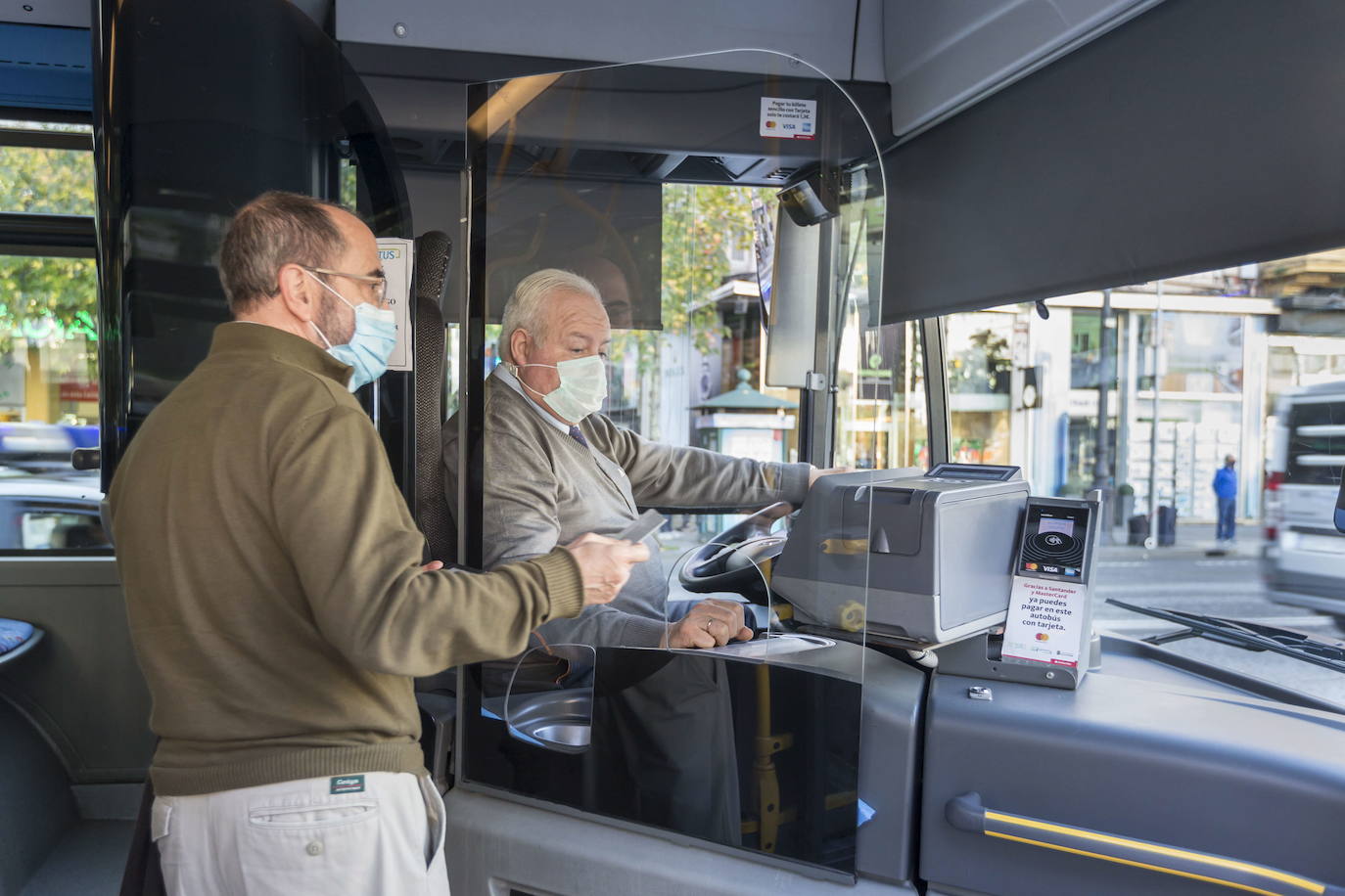 Imagen de un pasajero y el conductor de un autobús municipal.