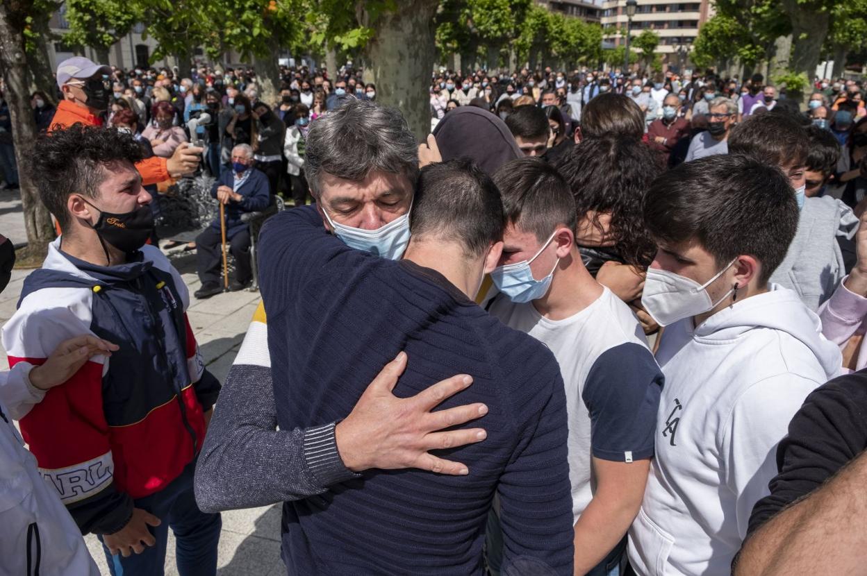 Varios jóvenes abrazan a los padres de Mario Fuentes en una concentración de repulsa en Colindres. 