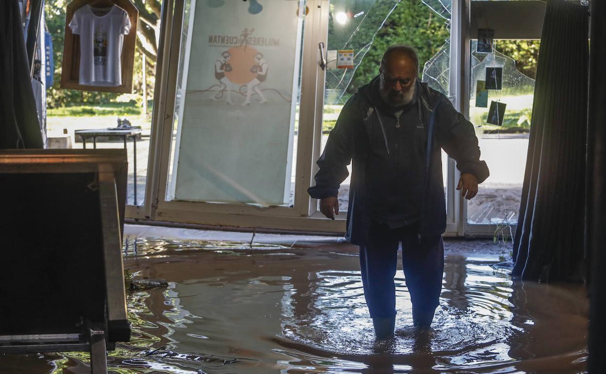 Un vecino camina entre el agua que todavía permanecía en muchos edificios en el día después de las inundaciones