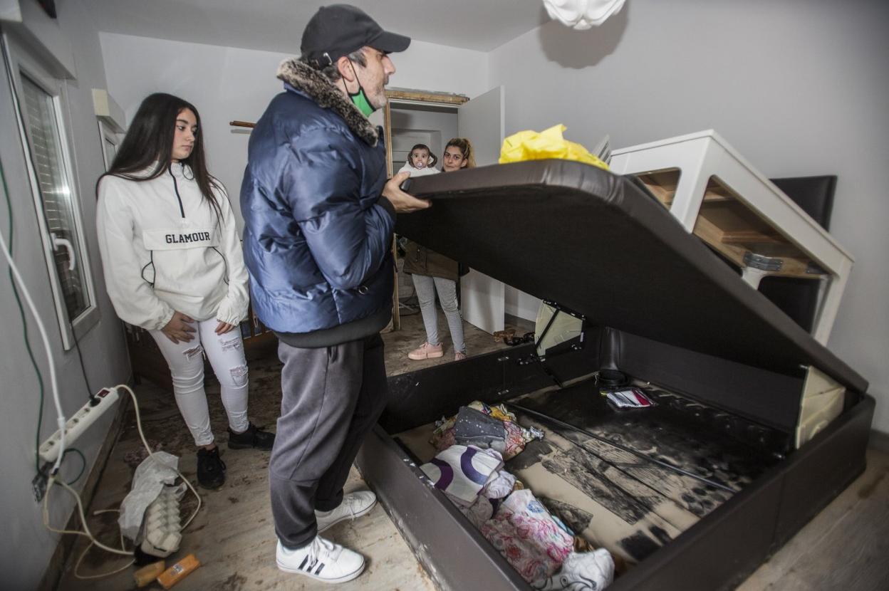 Ramón Rueda, su hija Desiré y su mujer, Yoana Leira, con la bebe en brazos, en una de las habitaciones de su casa de Vioño, destrozada. 