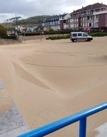 Imagen secundaria 2 - Imagen de esta mañana en el aparcamiento de la playa de Somo, cubierto por completo de arena, arrastrada por el temporal de viento y olas.