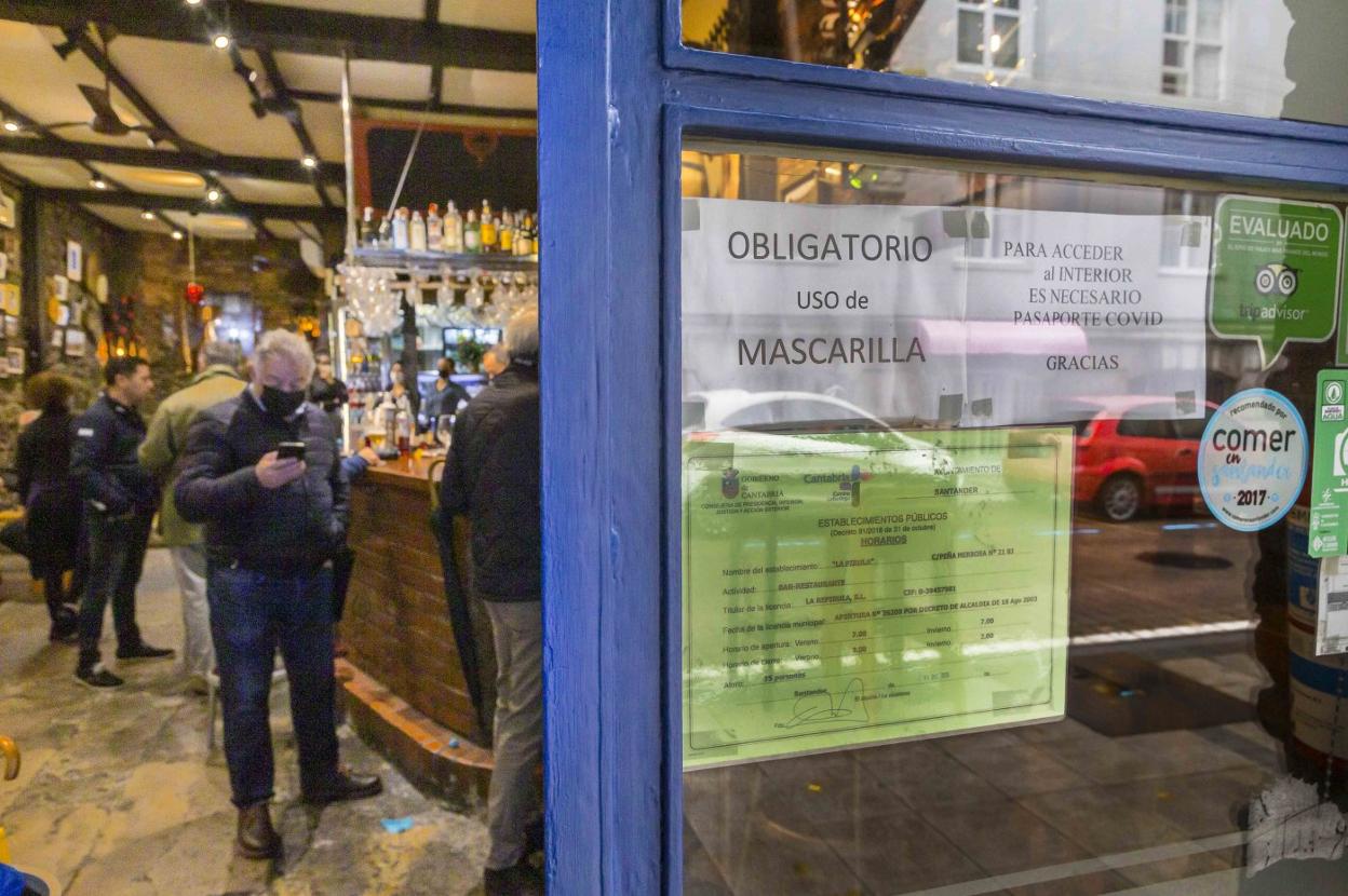 Un cartel advierte, a la entrada del bar La Pirula, en Peña Herbosa, de la necesidad de enseñar el pasaporte covid para acceder al local. roberto ruiz