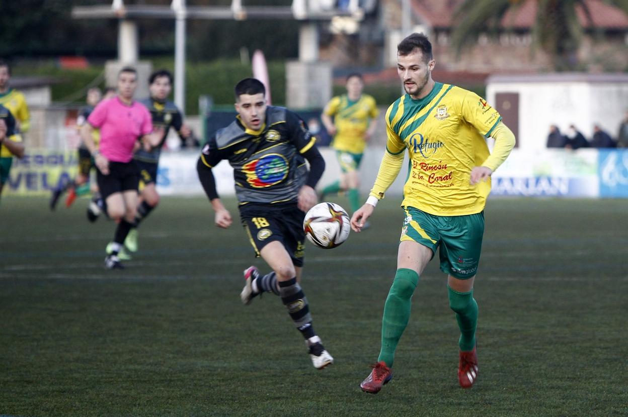 Javi Delgado, del Tropezón (derecha), intenta controlar el balón ante Pablo Bolado, del Cayón. Luis Palomeque