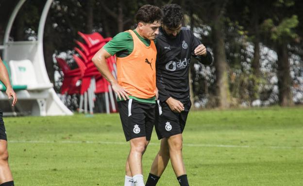 Diego Ceballos habla con Romo en un entrenamiento.