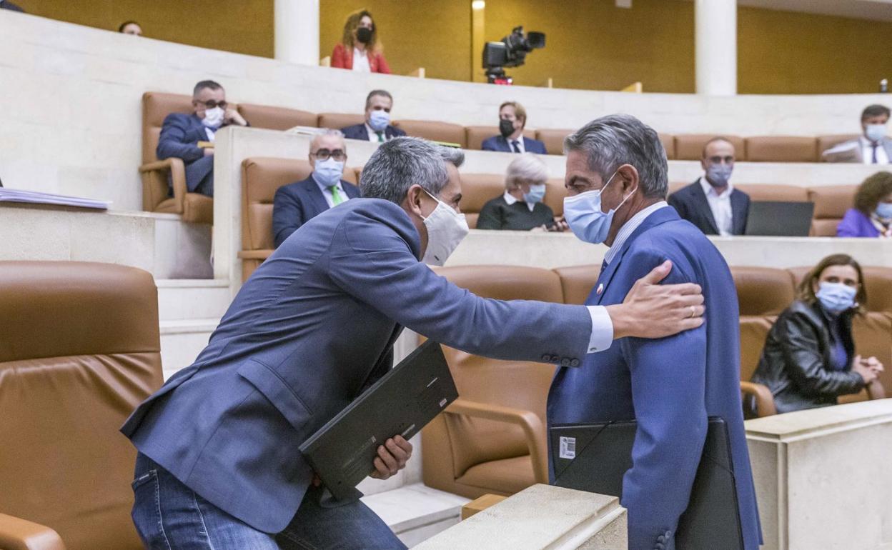 Pablo Zuloaga saluda a Miguel Ángel Revilla durante un pleno en el Parlamento de Cantabria. 