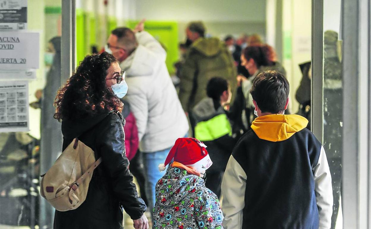 Una madre acompaña a sus hijos a vacunarse contra el covid en el centro de El Alisal.