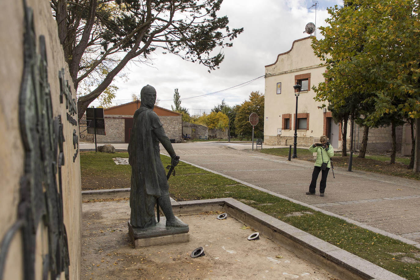 Una senderista fotografía la estatuta del Cid que hay en la localidad natal del Campeador.