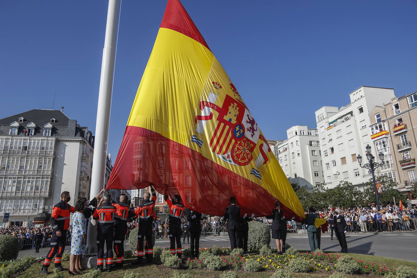 Un millar de personas asistió al izado de la enorme bandera de España que desde el 12 de octubre vuelve a ondear en Puertochico, un acto que se hizo coincidir con la celebración de la Fiesta Nacional