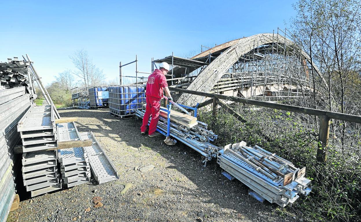 Un operario trabaja colocando el andamiaje para comenzar los trabajos de reparación de la pasarela. 