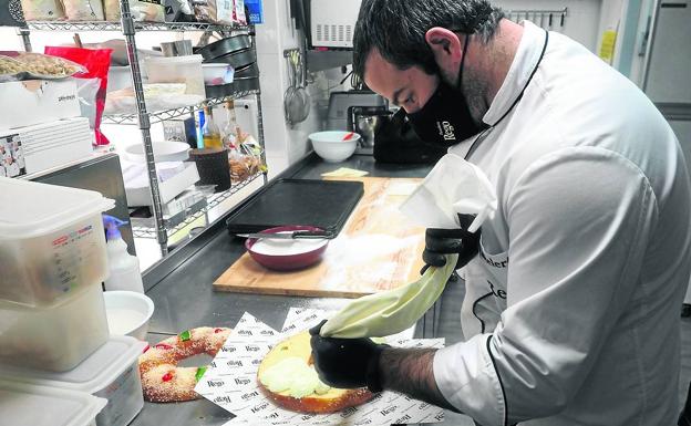 Ramón Diego Rego rellena con nata uno de los roscos en su obrador de Liérganes. 