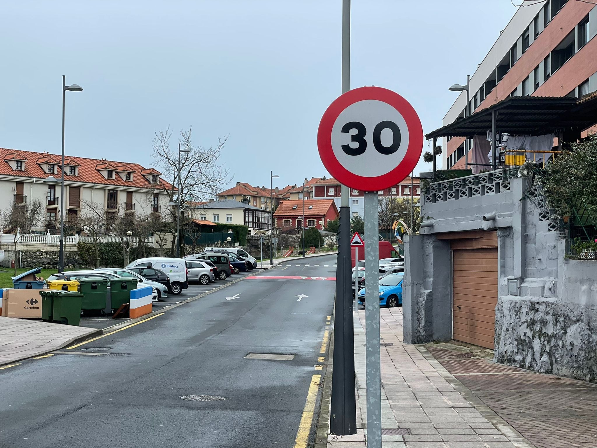 Una calle de El Astillero con una señal de prohibido circular a más de 30 k/h.