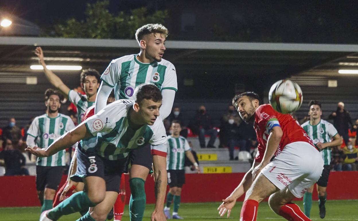 Gabi y Mirapeix, del Rayo Cantabria, intentan despejar un balón ante Vinatea, del Laredo.