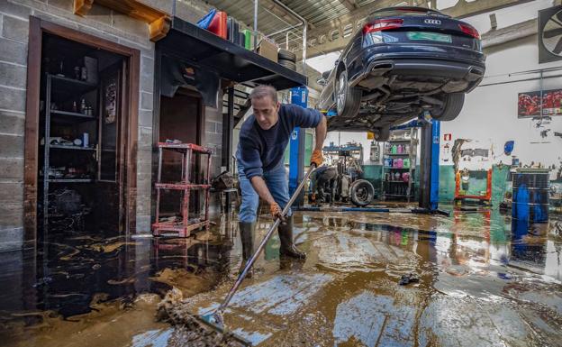 Uno responsable de Talleres Hermanos Edesa, ubicado en Marrón (Ampuero) limpia el barro tras las inundaciones