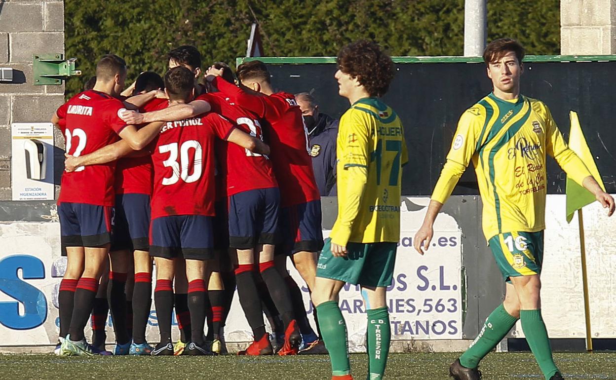 Higuera y Pablo García, del Tropezón, en primer término, mientras el Osasuna B celebra un gol.