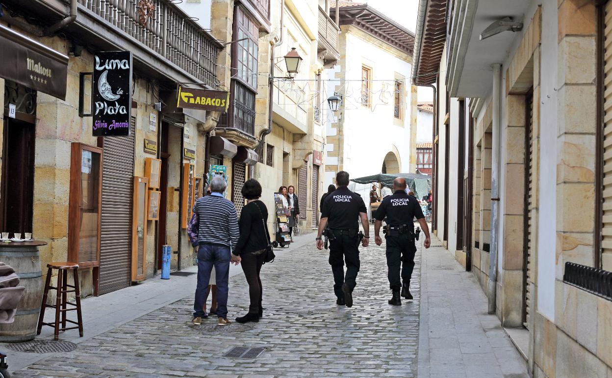 Dos policías locales patrullan por el centro de Comillas. 