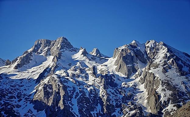 El Torrecerredo, techo de los Picos de Europa, se asoma sutil tras el Neverón de Urriellu , jugando con la perspectiva de la altura 