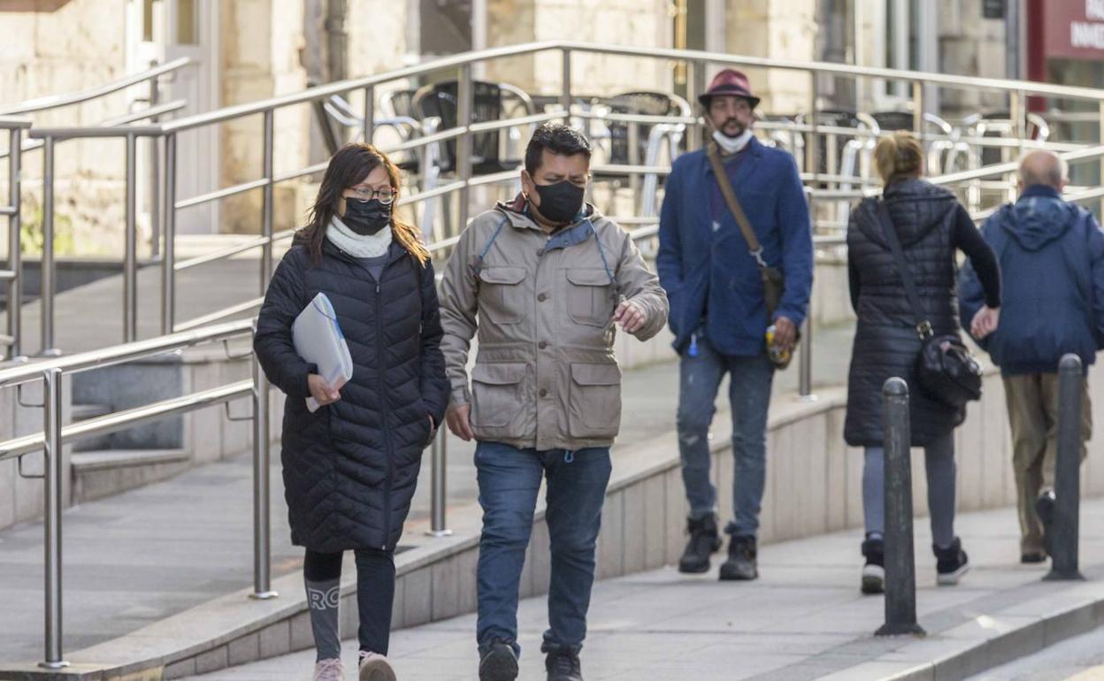 Imagen de archivo de gente paseando por una calle de Santander, con y sin mascarillas.