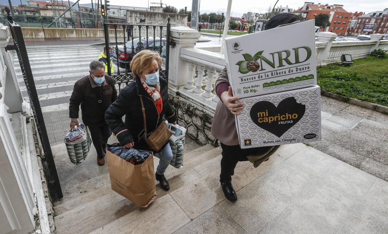 Rocío Balbontín y Juan Peñalva transportan ropa y medicamentos que han donado en el centro cívico de María Cristina, en la avenida de General Dávila (Santander). 