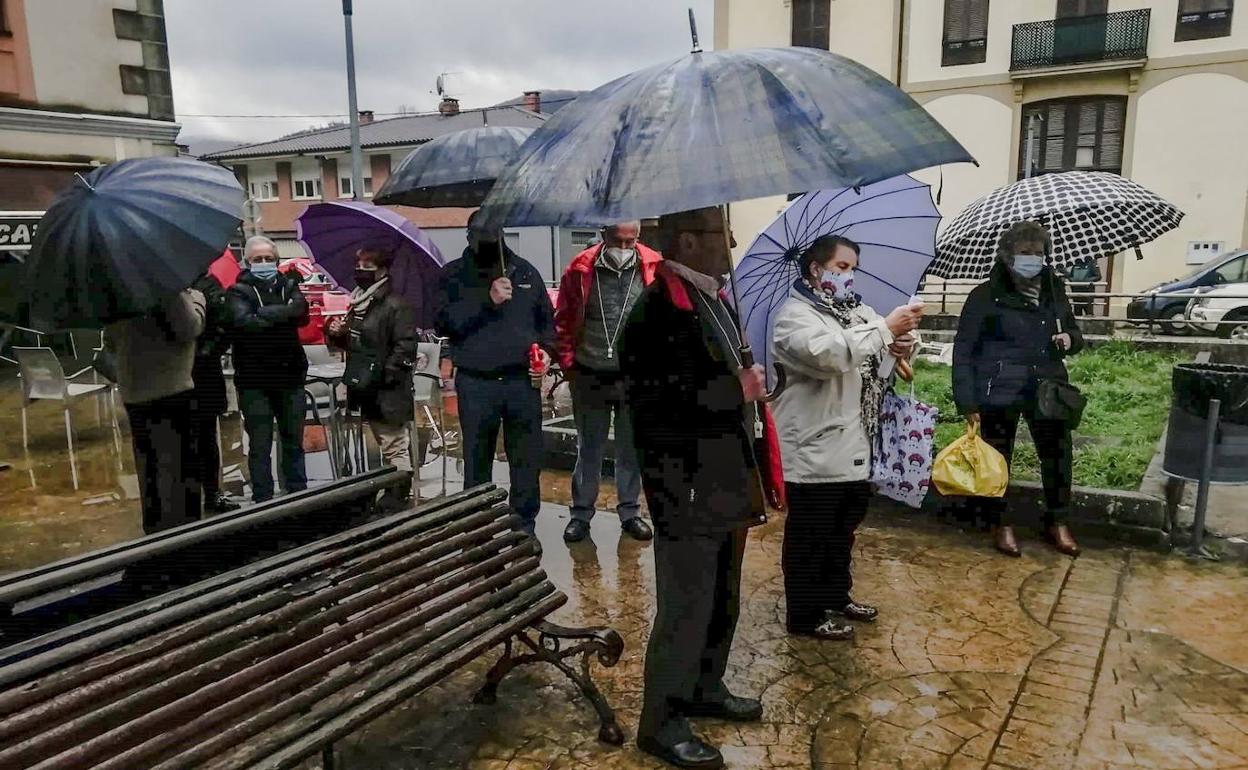 Un momento de la concentración bajo la lluvia en la plaza de la Chiquita de Guriezo. 